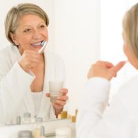 Frau betreibt Mundhygiene
